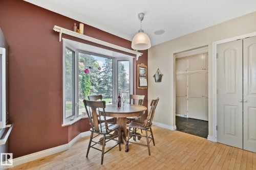 Bay window with exterior views, light wood-finish flooring, and a contemporary ceiling light fixture - 7306 21 Avenue Nw, Edmonton, AB - Indoor Photo Showing Dining Room