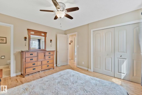 Hardwood flooring throughout featuring a ceiling fan with integrated lighting, bi-fold closet doors, and neutral wall tones - 7306 21 Avenue Nw, Edmonton, AB - Indoor Photo Showing Bedroom