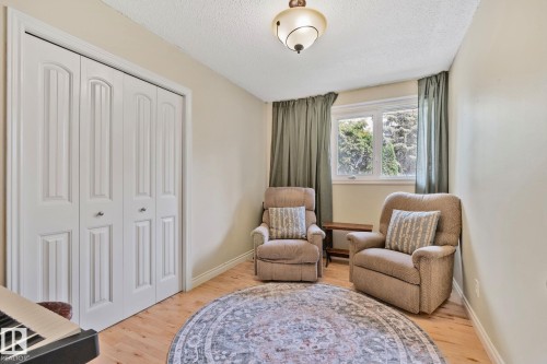 Room featuring light wood-finish flooring, white bifold closet doors, and a double-pane window with surrounding nature - 7306 21 Avenue Nw, Edmonton, AB - Indoor Photo Showing Bedroom