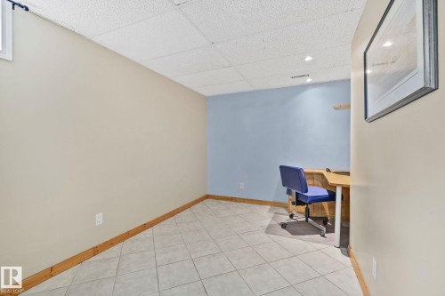 Neutral-toned walls with wood baseboards and light-colored square tile flooring - 7306 21 Avenue Nw, Edmonton, AB - Indoor Photo Showing Other Room