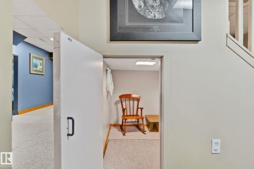 White door with a black handle providing access to an interior room with carpet flooring and an overhead light - 7306 21 Avenue Nw, Edmonton, AB - Indoor Photo Showing Other Room