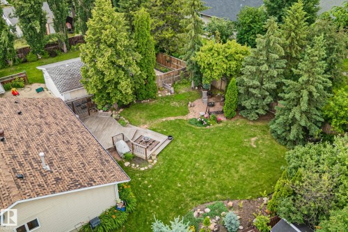 Expansive backyard featuring a manicured lawn, multi-level wooden deck, and mature landscaping - 7306 21 Avenue Nw, Edmonton, AB - Outdoor