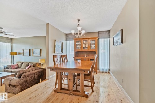 Dining area featuring wood-finish flooring and a multi-light chandelier - 7306 21 Avenue Nw, Edmonton, AB - Indoor