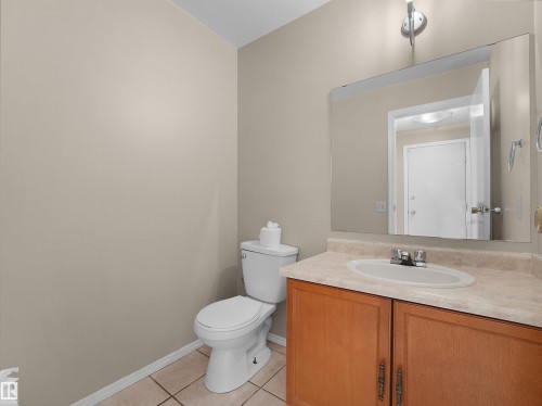 Bathroom vanity with a white ceramic sink, chrome faucet, and wood-finish cabinetry - 3509 43A Avenue Nw, Edmonton, AB - Indoor Photo Showing Bathroom