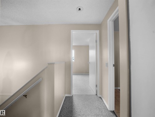 Carpeted hallway with light neutral walls and white trim - 3509 43A Avenue Nw, Edmonton, AB - Indoor Photo Showing Other Room