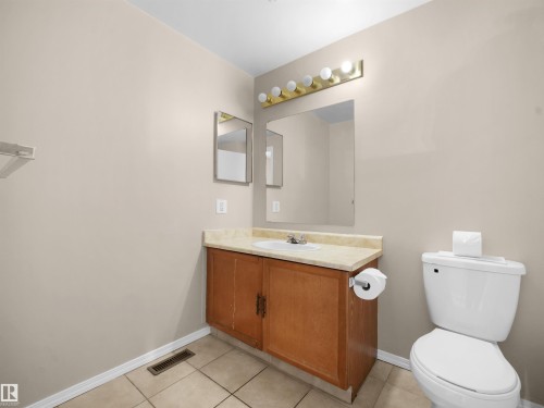 Neutral-toned walls complement a wood-finish vanity with an integrated sink and light-toned countertop - 3509 43A Avenue Nw, Edmonton, AB - Indoor Photo Showing Bathroom