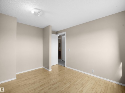 Spacious room featuring wood-finish flooring, light neutral wall tones, and white trim - 3509 43A Avenue Nw, Edmonton, AB - Indoor Photo Showing Other Room