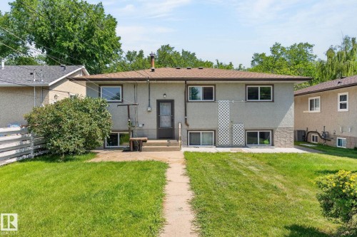 Rear exterior featuring a brown shingle roof and grey stucco finish - 12908 104 Street Nw, Edmonton, AB - Outdoor