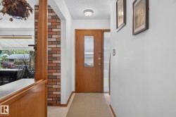 Warm wood-finish entry door with a frosted glass insert, flanked by a frosted glass sidelight - 