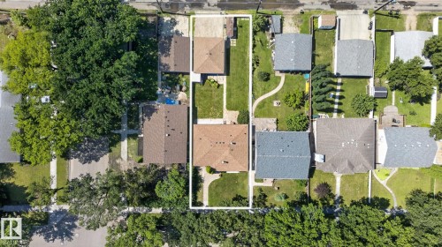 Aerial perspective showcasing a property with a brown shingle roof, a verdant lawn, and mature trees providing substantial shade - 12908 104 Street Nw, Edmonton, AB -  With View