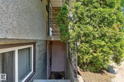 Exterior featuring a gravel-textured facade, brick accents, and a lower-level entrance with a window - 