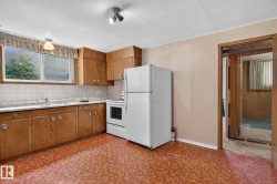 Kitchen featuring wood-finish cabinetry, white appliances, and a tiled backsplash - 