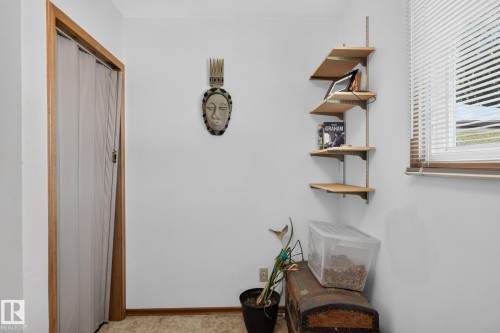 White walls with wood trim, featuring a corner shelving unit with three shelves - 12908 104 Street Nw, Edmonton, AB - Indoor