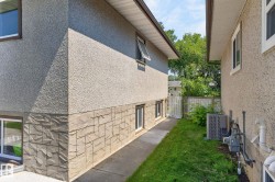 Property exterior showcasing a textured stucco finish and a stone veneer foundation - 