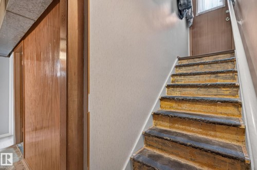 Staircase featuring wood risers and treads, with a white painted handrail - 12908 104 Street Nw, Edmonton, AB - Indoor Photo Showing Other Room