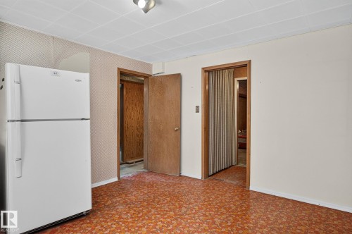 Orange patterned flooring, ceiling tiles, and solid core doors - 12908 104 Street Nw, Edmonton, AB - Indoor Photo Showing Other Room