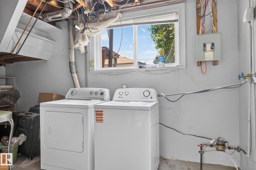 Laundry area featuring a window, painted walls, exposed ceiling joists, and a visible electrical panel - 12908 104 Street Nw, Edmonton, AB - Indoor Photo Showing Laundry Room