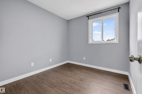 Neutral gray walls complement wood-finish flooring with white baseboards - 18116 81 Avenue, Edmonton, AB 