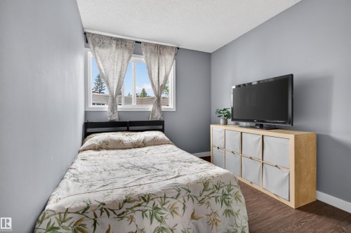 Interior room featuring light gray walls, dark wood-finish flooring, and a white framed window - 18116 81 Avenue, Edmonton, AB 