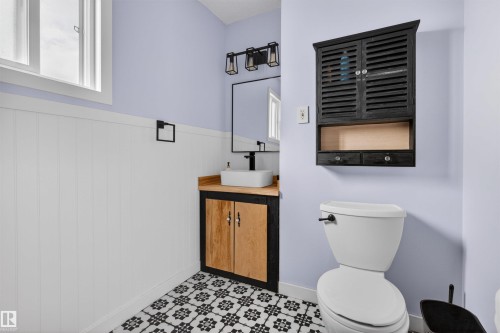 Bathroom featuring patterned floor tiling, white wainscoting, and a light-colored wall - 18116 81 Avenue, Edmonton, AB 