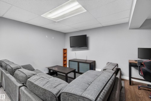 Recessed ceiling with acoustic tiles, integrated fluorescent lighting, wood-finish flooring, neutral gray walls, and baseboard trim - 18116 81 Avenue, Edmonton, AB 
