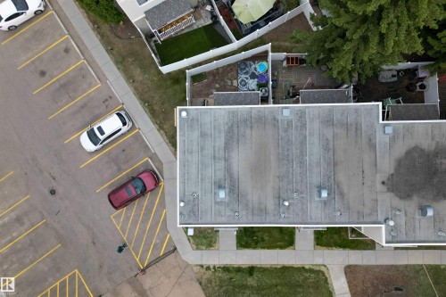 Building exterior with flat roofing, surrounded by paved parking areas, sidewalks, and landscaped grounds - 18116 81 Avenue, Edmonton, AB 