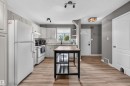 Well-appointed kitchen featuring white cabinetry, light countertops, subway tile backsplash, and wood-finish flooring - 18116 81 Avenue, Edmonton, AB 