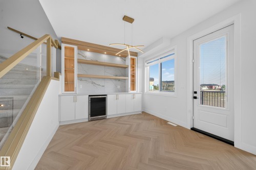 Built-in cabinetry with a beverage cooler, wood-finish shelving, and integrated lighting - 2808 191 Street Nw, Edmonton, AB - Indoor Photo Showing Other Room