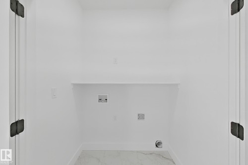 Dedicated utility alcove with a built-in shelf, plumbing hookups, and electrical outlets - 4215 63 Street, Beaumont, AB - 