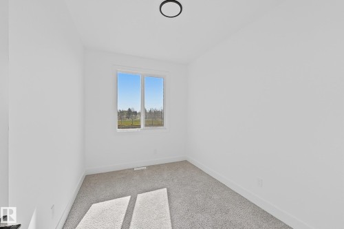 Bright room with plush grey carpeting and crisp white walls - 4215 63 Street, Beaumont, AB - Indoor Photo Showing Other Room