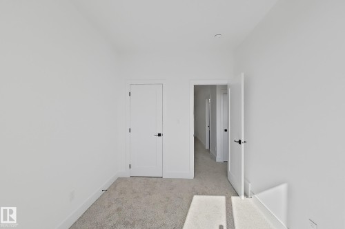 Carpeted interior space with white walls and baseboards - 4215 63 Street, Beaumont, AB - Indoor Photo Showing Other Room