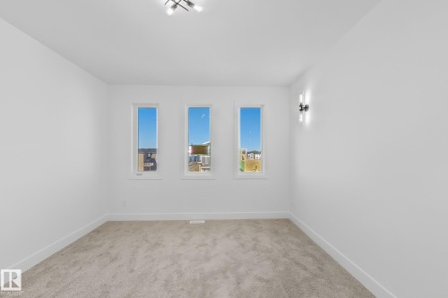 Room with three rectangular windows providing natural light - 4215 63 Street, Beaumont, AB - Indoor Photo Showing Other Room