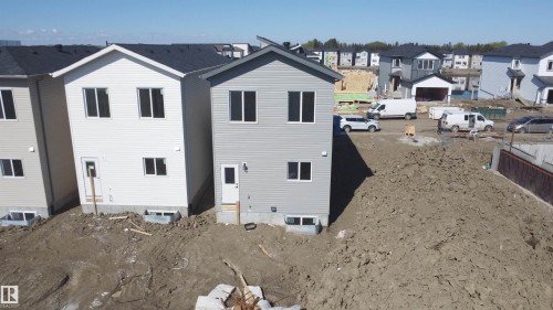 Gray two-story residence featuring light siding and a dark shingled roof - 4215 63 Street, Beaumont, AB - Outdoor