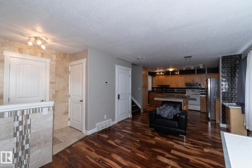 Open-concept living area featuring rich wood-finish flooring - 11915 77 Street Nw, Edmonton, AB - Indoor