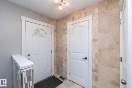 Entryway featuring a white paneled door with an arched transom window - 11915 77 Street Nw, Edmonton, AB - Indoor