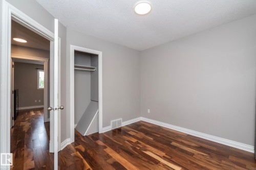 Room featuring wood-finish flooring, light grey painted walls, white baseboards, and a flush-mount ceiling light - 11915 77 Street Nw, Edmonton, AB - Indoor Photo Showing Other Room