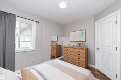 Neutral-toned room featuring a white window, wood-finish flooring, and a white paneled door - 