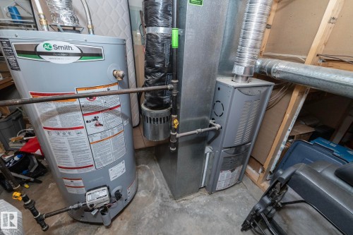 Mechanical room featuring a water heater, furnace, and exposed ductwork - 11915 77 Street Nw, Edmonton, AB - Indoor Photo Showing Basement