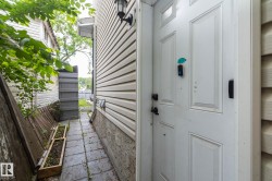 White paneled exterior door with black hardware, featuring a secure entry system - 