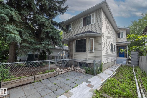 Two-story property featuring light-colored siding and a blue entry door - 11915 77 Street Nw, Edmonton, AB - Outdoor