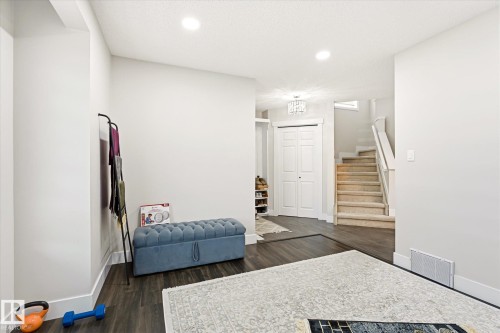 Expansive room featuring wood-finish flooring, recessed lighting, and a white bi-fold door - 4317 152 Avenue Nw, Edmonton, AB - Indoor Photo Showing Other Room
