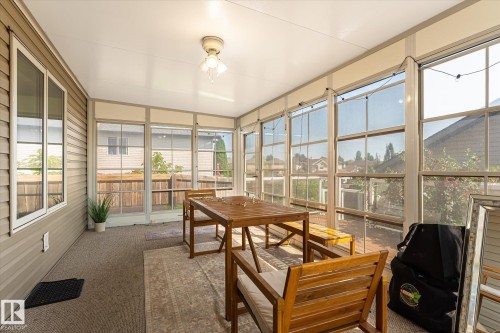 Screened-in porch featuring a full-light entry door, extensive window panels, and a ceiling-mounted light fixture - 4317 152 Avenue Nw, Edmonton, AB - Indoor Photo Showing Other Room
