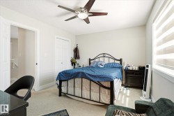 Interior room featuring neutral wall paint and carpeting, a ceiling fan with integrated lighting, a window with horizontal blinds, and a bi-fold closet door - 
