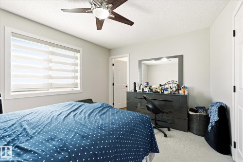 Bright room featuring a window with banded shades, light-colored walls, and a ceiling fan with integrated lighting - 4317 152 Avenue Nw, Edmonton, AB - Indoor Photo Showing Bedroom