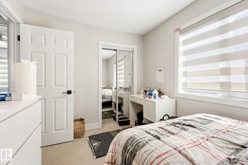 Room featuring a large window with horizontal blinds, neutral wall paint, and carpet flooring - 4317 152 Avenue Nw, Edmonton, AB - Indoor Photo Showing Bedroom