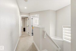 Upper level hallway featuring light gray walls, white trim, and recessed lighting - 