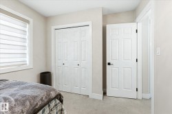 Bedroom with neutral wall tones, light-toned carpet flooring, and a window with horizontal blinds - 