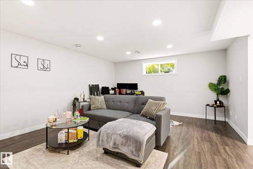 Spacious room featuring wood-finish flooring, recessed lighting, and a neutral color palette - 4317 152 Avenue Nw, Edmonton, AB - Indoor