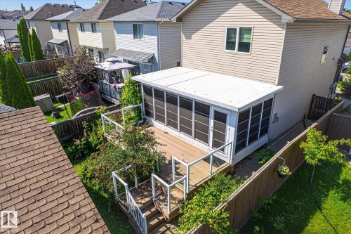 Rear exterior featuring a screened-in porch with a wood-finish deck and glass panel railings - 4317 152 Avenue Nw, Edmonton, AB - Outdoor With Exterior