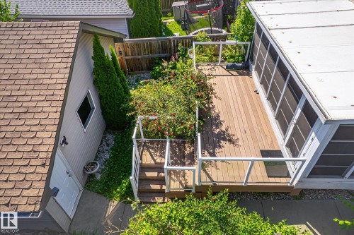 Wood-finish deck with white railings and an attached screened-in porch - 4317 152 Avenue Nw, Edmonton, AB - Outdoor With Exterior